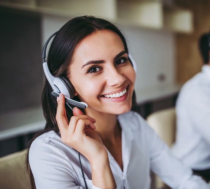 How can I help you? Beautiful call center workers in headphones are working at modern office.